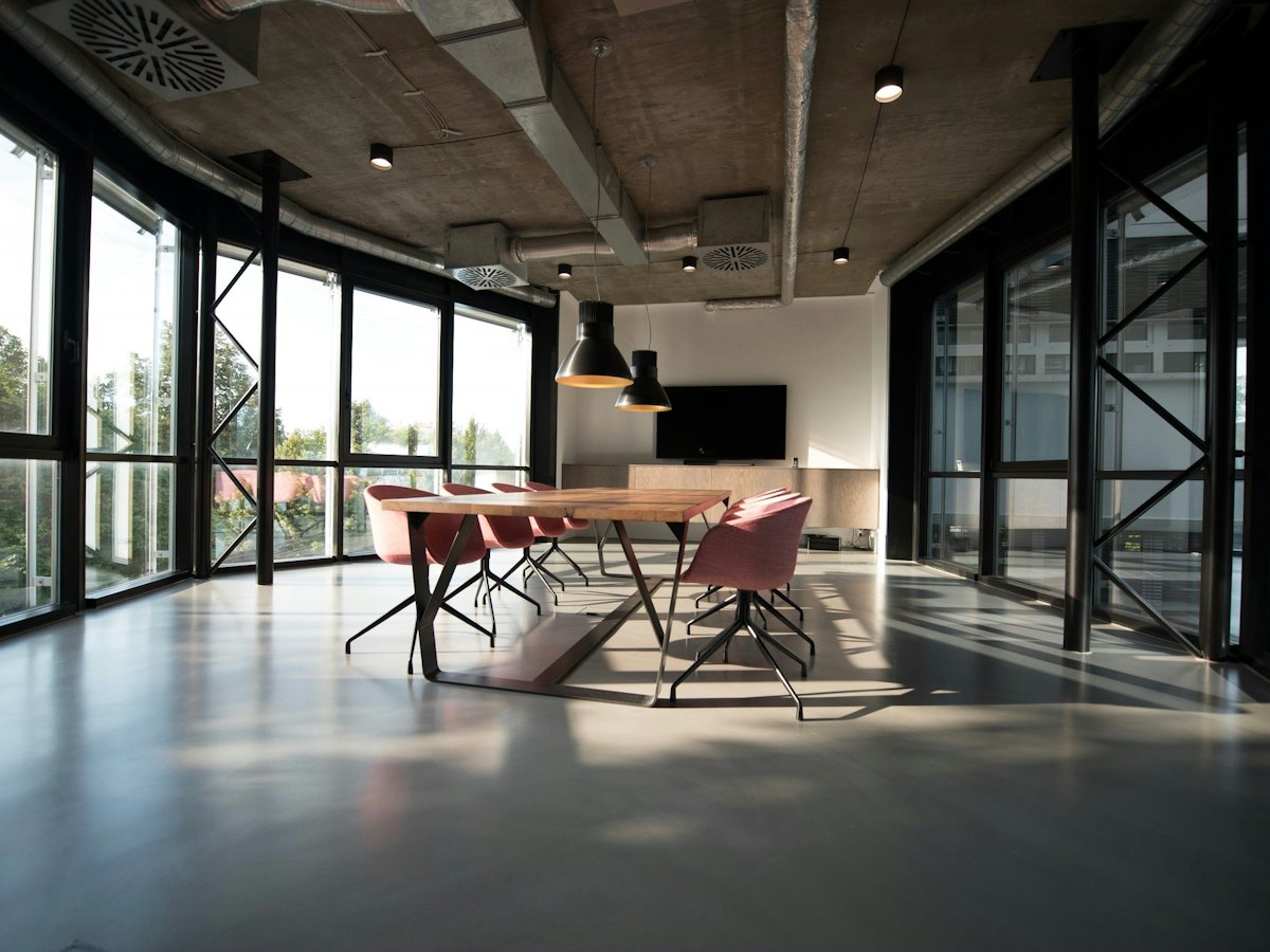 A bright open office with glass walls and a meeting table